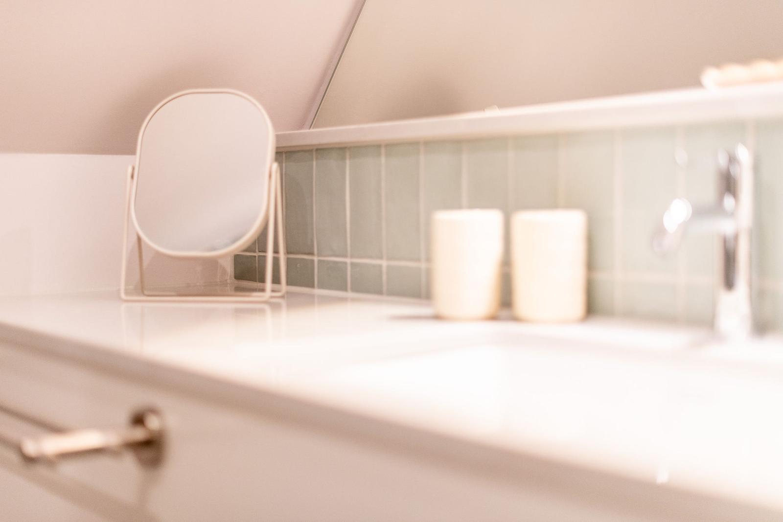 Bathroom with mirror, soap dispenser, and sink