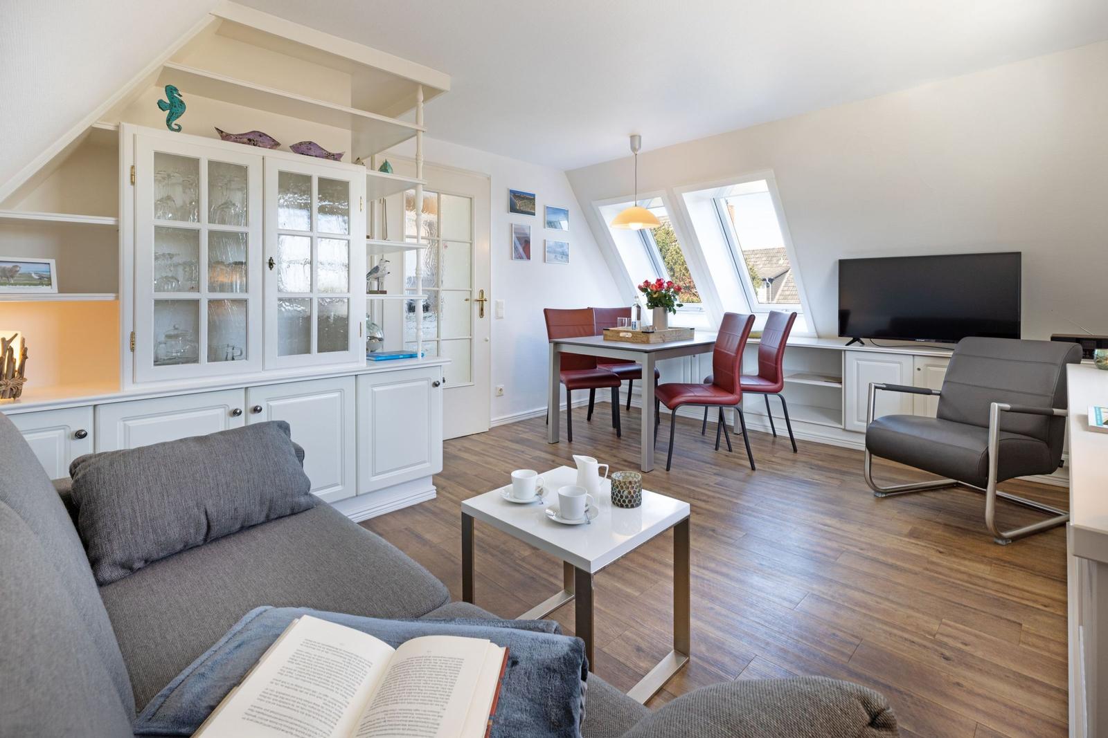 Wohn- und Essbereich mit Dachfenstern, Sofa, TV und Esstisch.