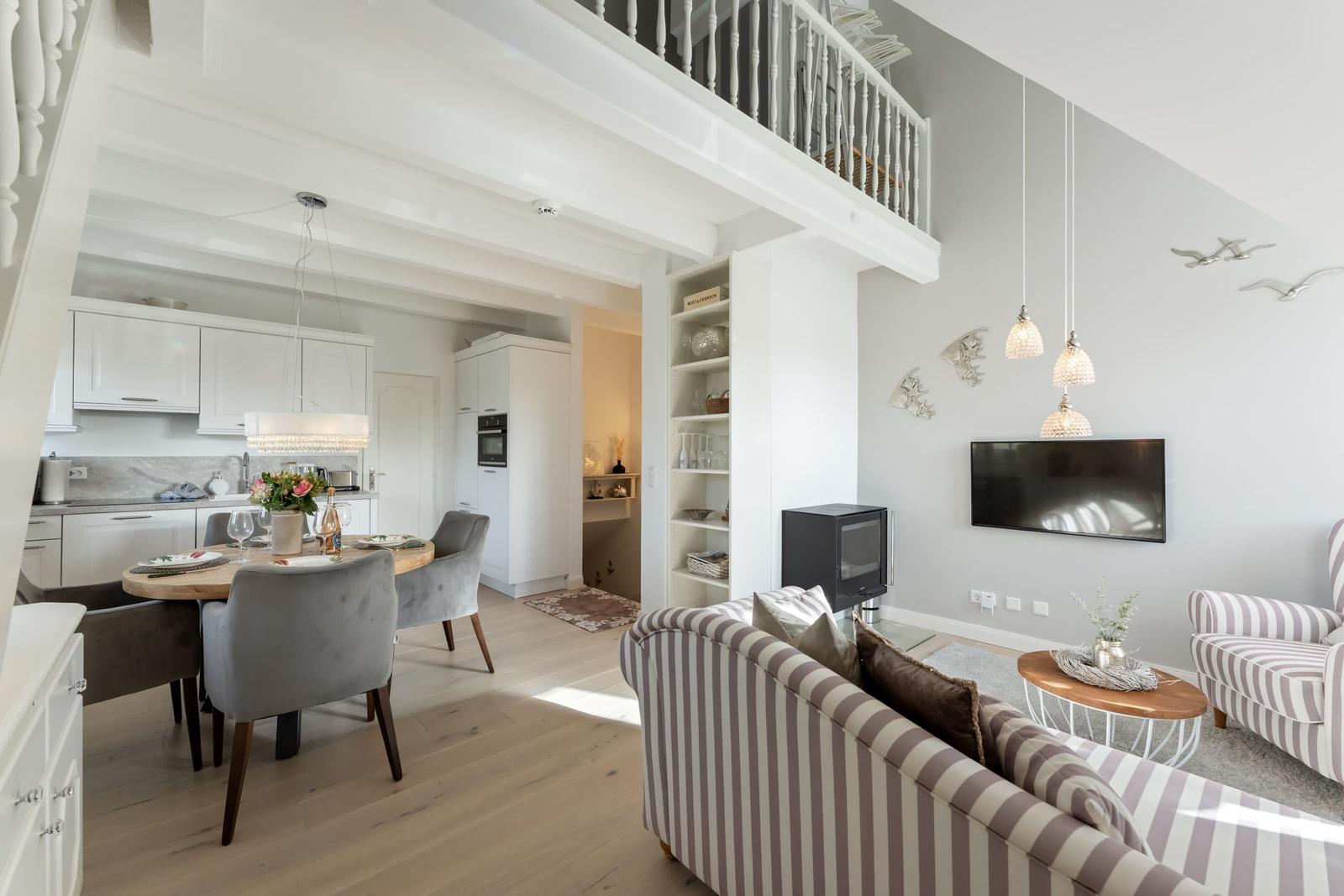 Wohn- und Essbereich mit Küchenbereich und Balkon. Möbel und Einrichtung sichtbar.