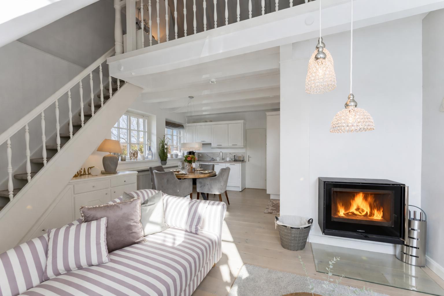 Wohnzimmer mit Kamin, Sofa und Blick in die Küche
