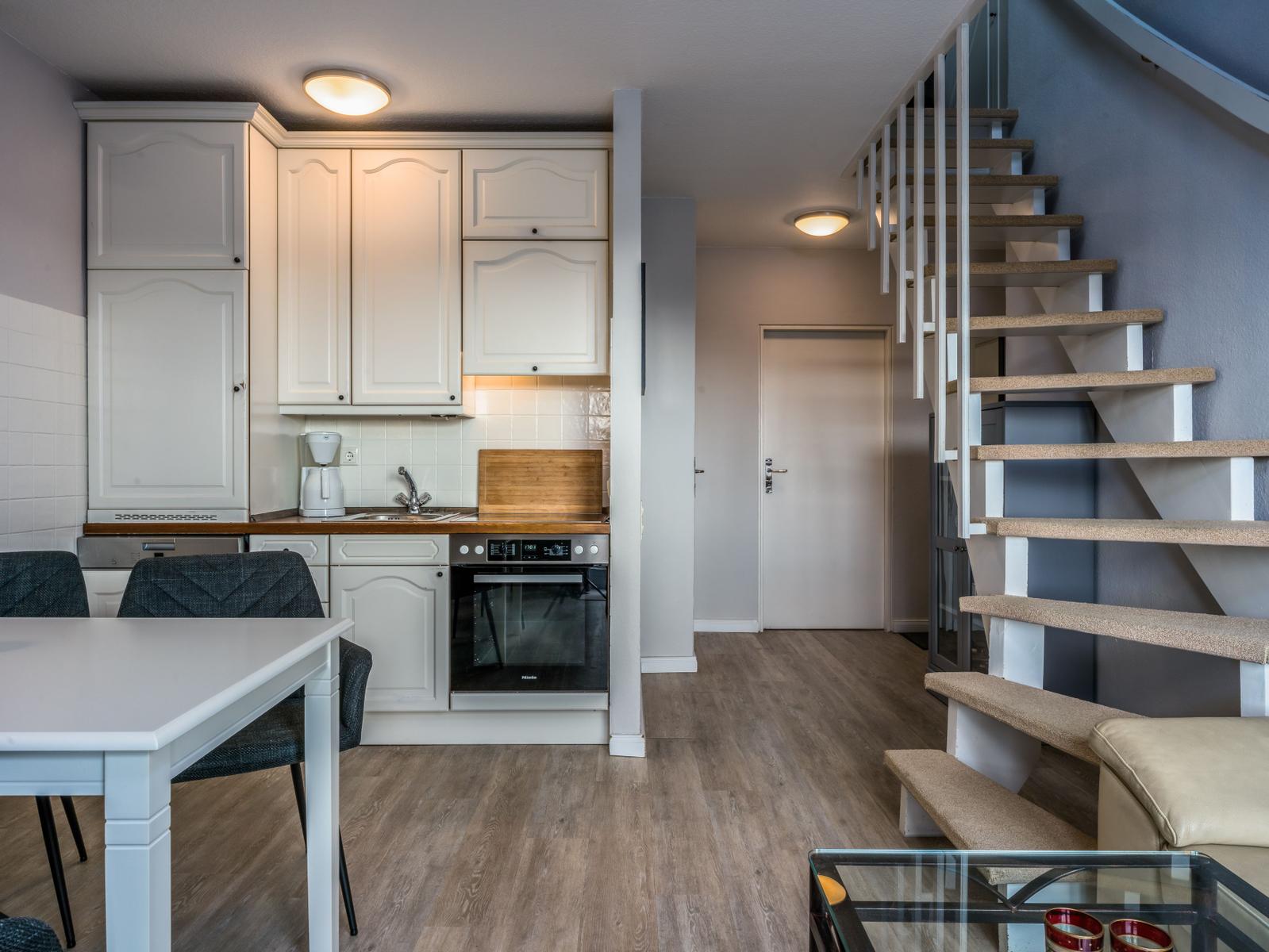 Küche mit Essbereich und Treppe zur oberen Etage.