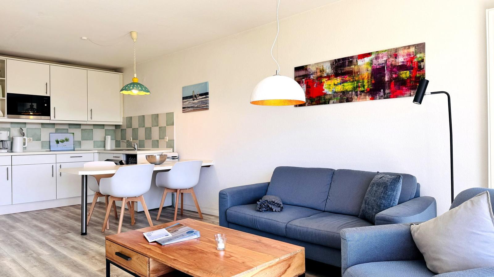 Wohnbereich mit Sofa, Couchtisch und Küchenbereich mit Essplatz.