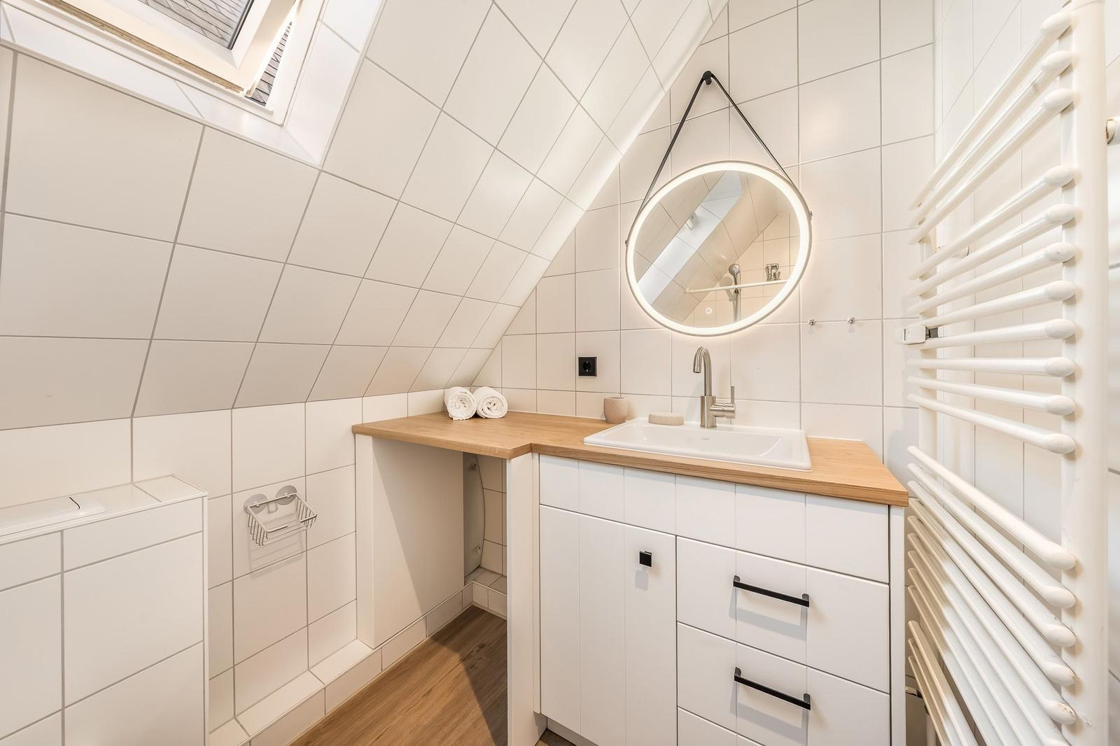 Badezimmer mit Dachschrägen, Waschbecken und Heizkörper