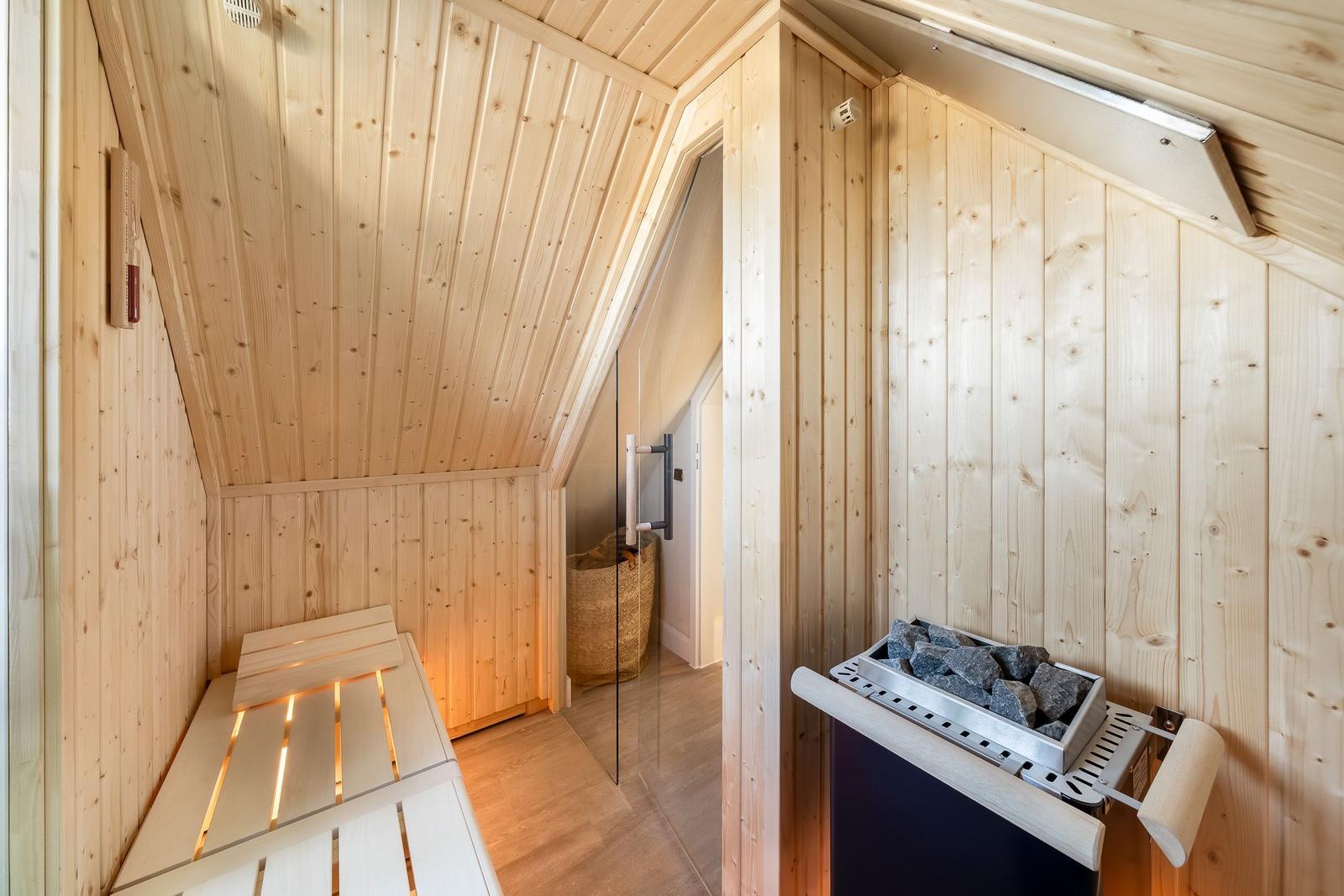 Sauna mit Holzwand, Sitzbank und Steinkiste