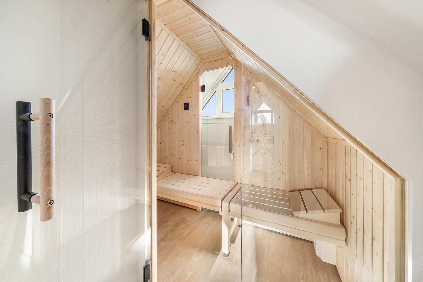 Sauna mit Holzbank und Glaswand, Dachneigung sichtbar