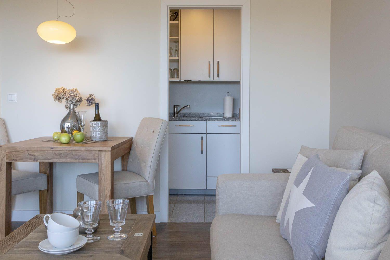 Wohnzimmer mit Sofa für zwei Personen sowie einen Sessel
