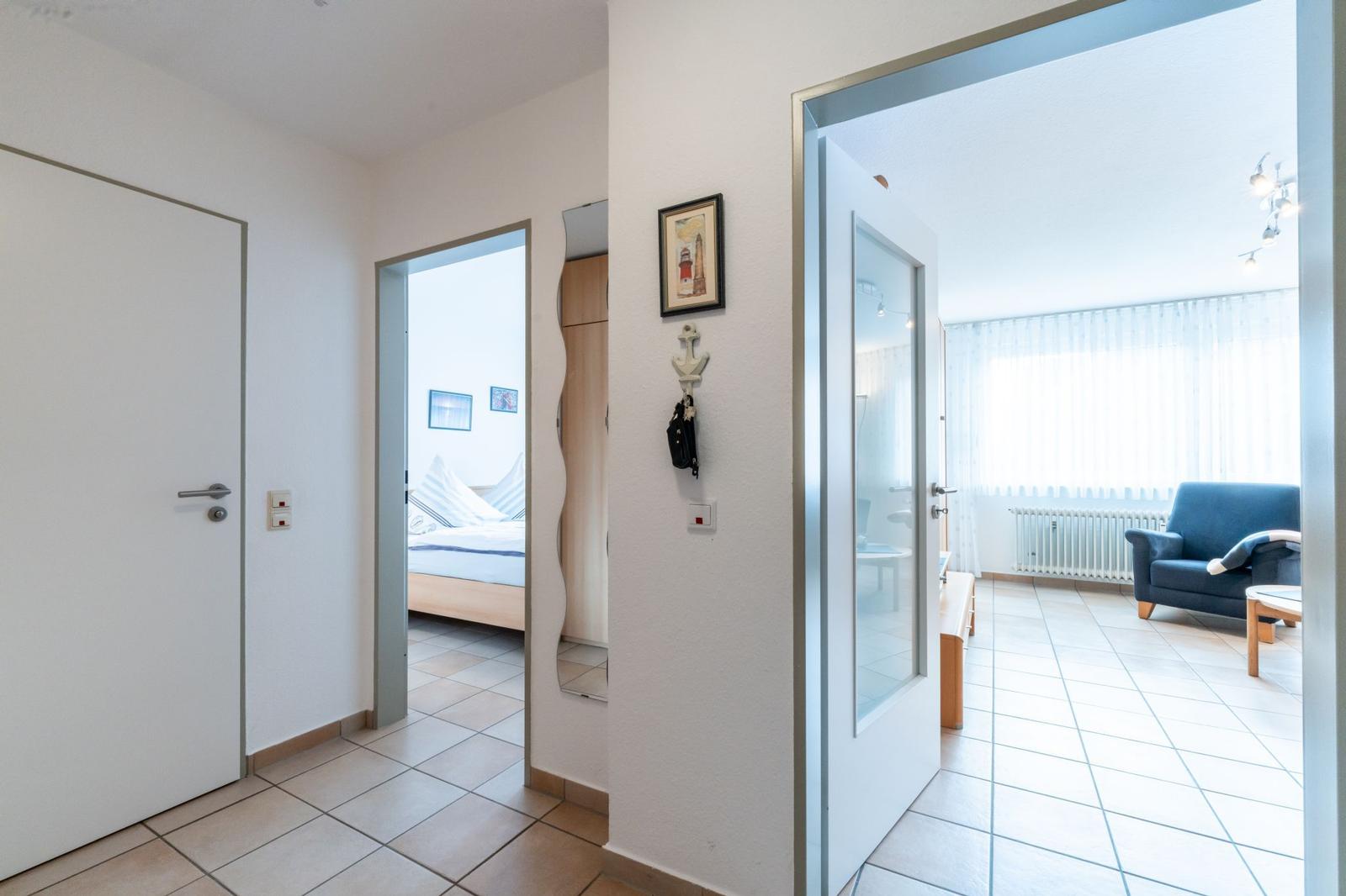 Haus mit Flur, Schlafzimmer und Wohnzimmer mit blauem Sofa.