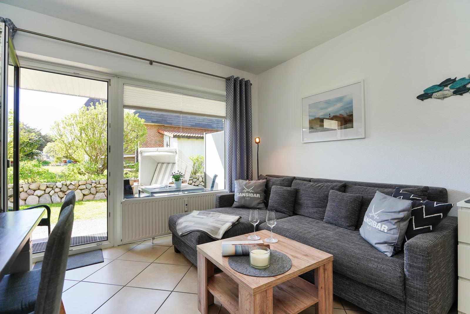 Wohnzimmer mit Sofa, Couchtisch und Blick auf den Garten.