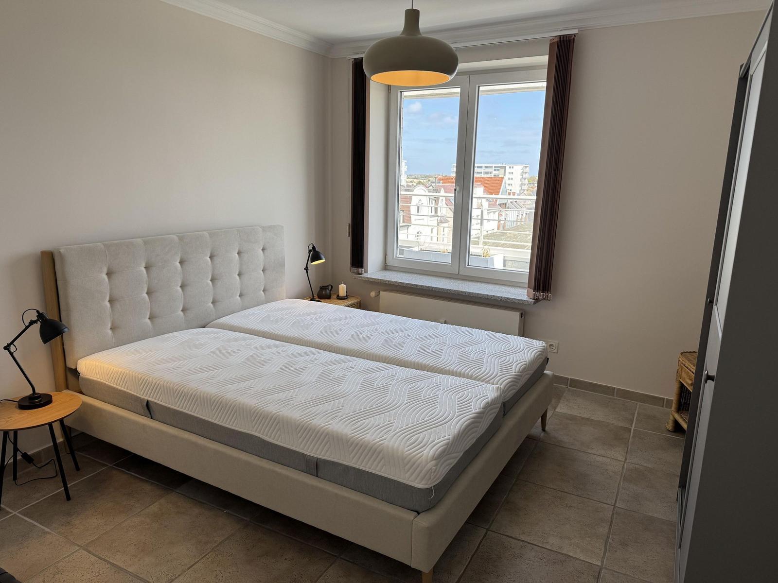 Bedroom with double bed, window, and nightstands.