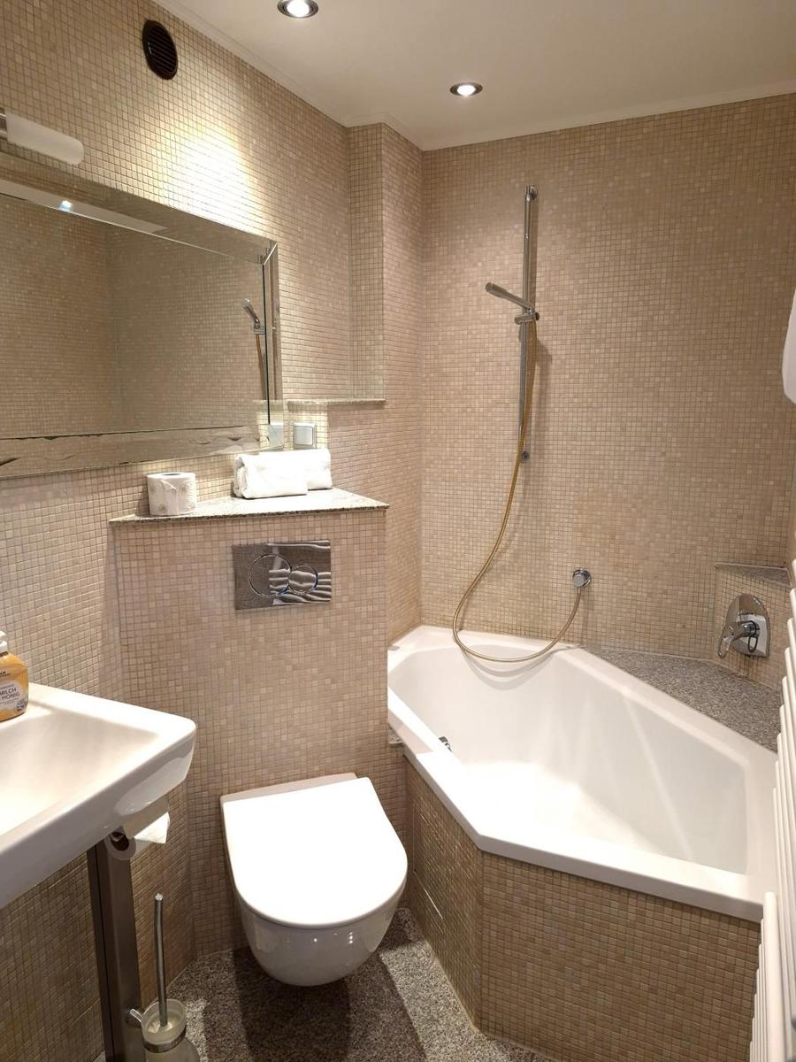 Badezimmer mit Badewanne, Dusche, WC und Waschbecken.