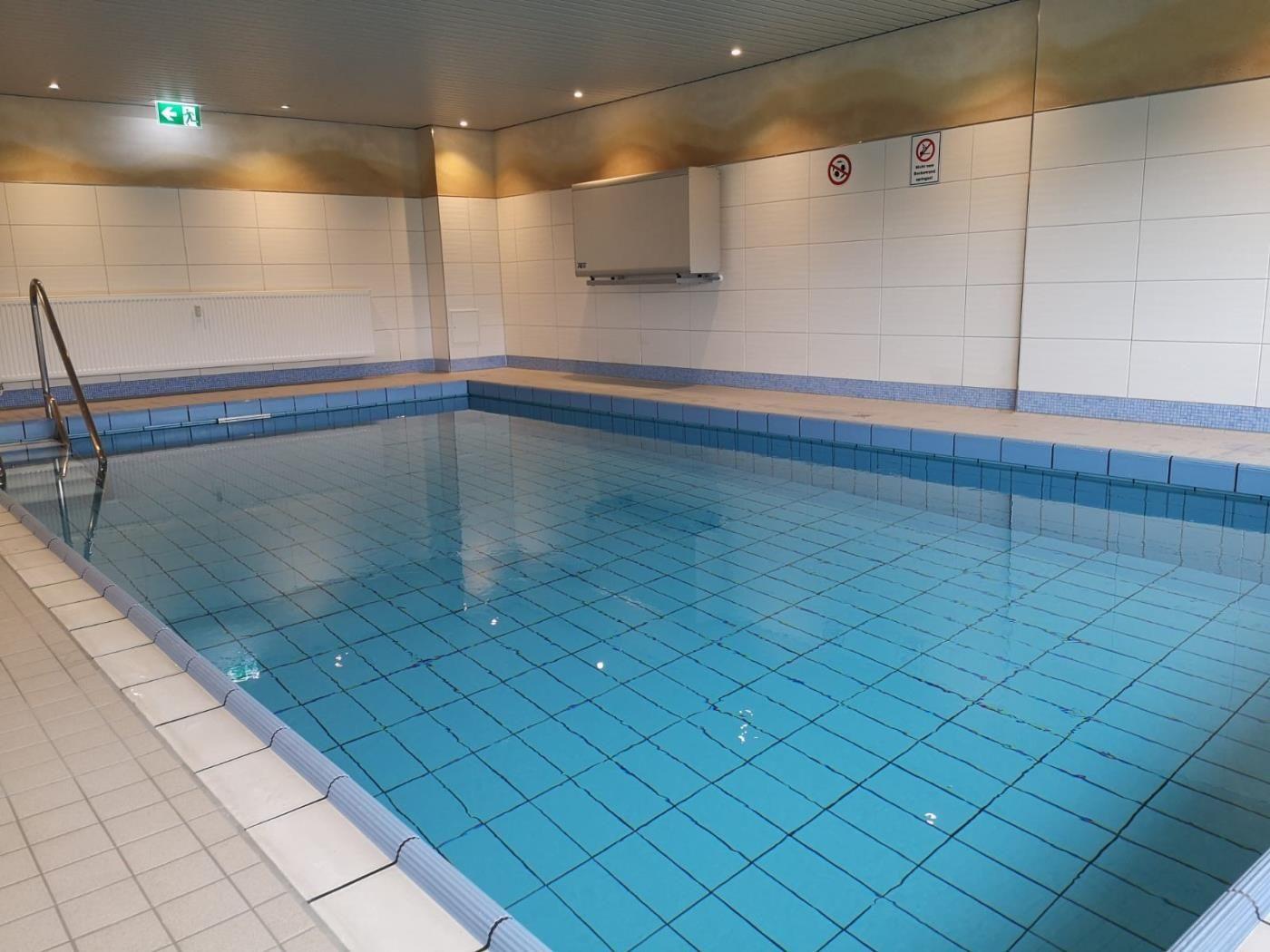 Innenpool mit blauen Fliesen und Aufstiegsleiter an der Wand