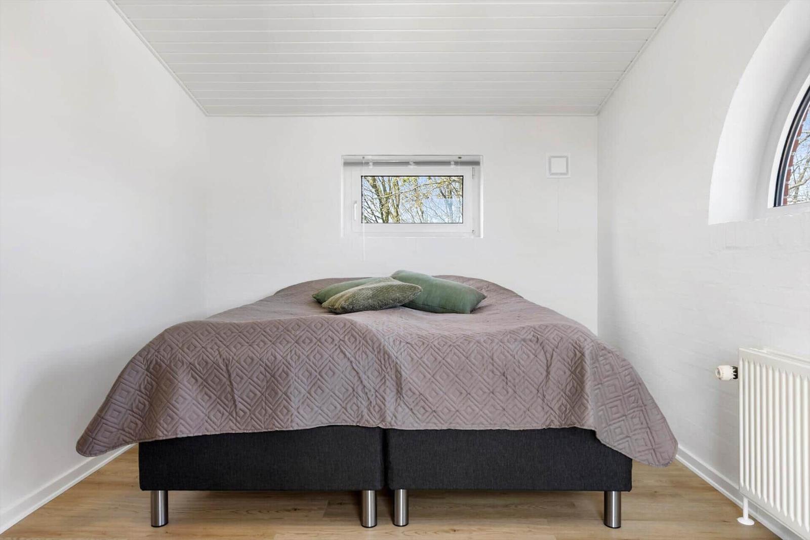 Bedroom with bed, window, and radiator.