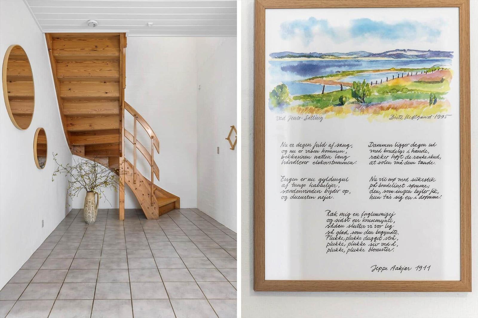 Wooden staircase in white room, wall picture with landscape and text