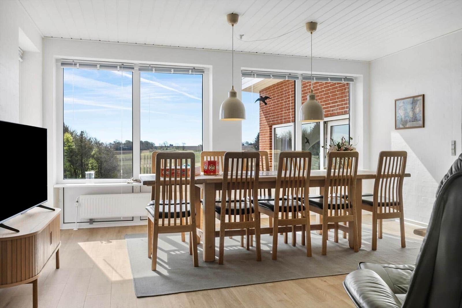 Dining room with wooden table, chairs, and view of fields