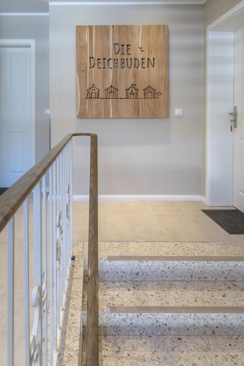 Haus mit Holzschild Die Deichbuden und Treppe mit Terrazzoboden