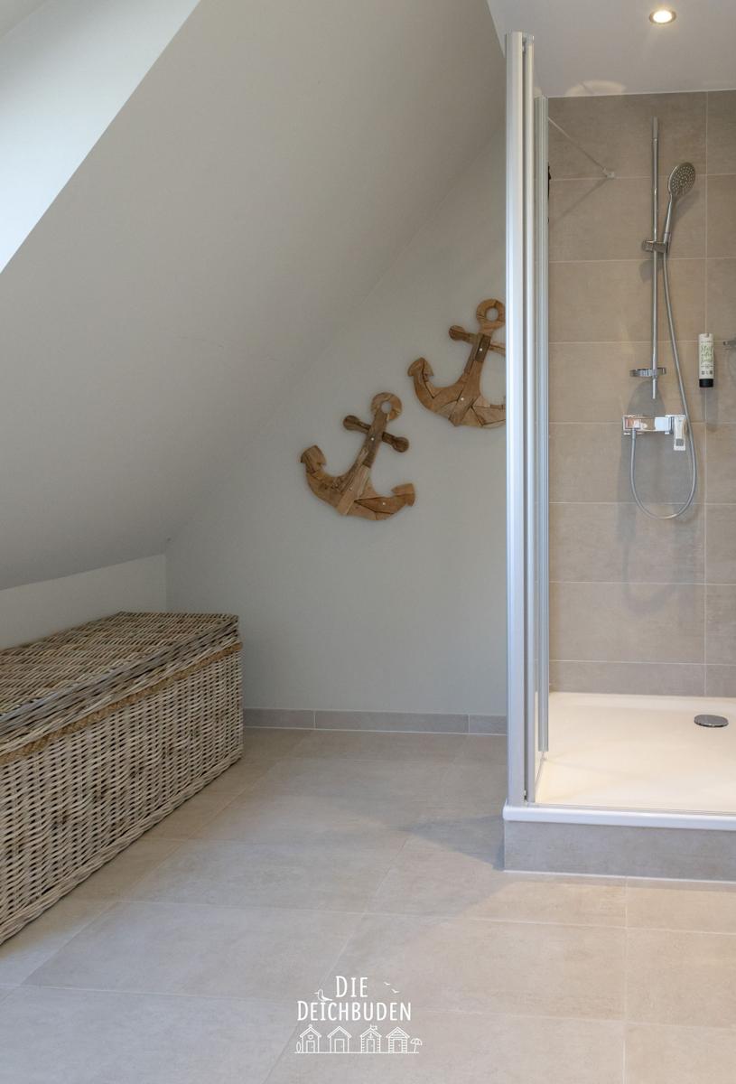 Dusche mit Glaswand, Wanddekoration aus Holzanker und Korb auf dem Boden
