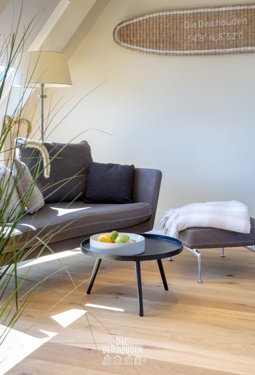 Ein Wohnbereich mit Sofa, Beistelltisch und Wanddekoration.