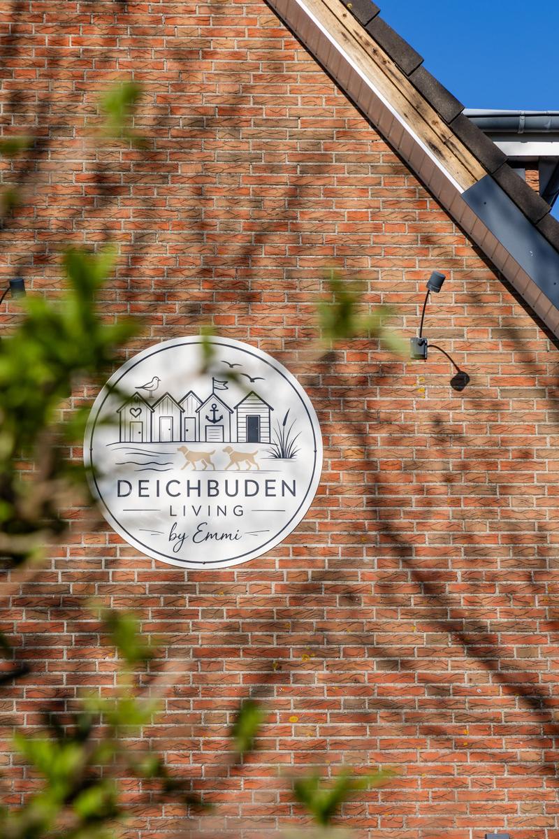 Wohnungsschild an Backsteinmauer mit Strandmotiv