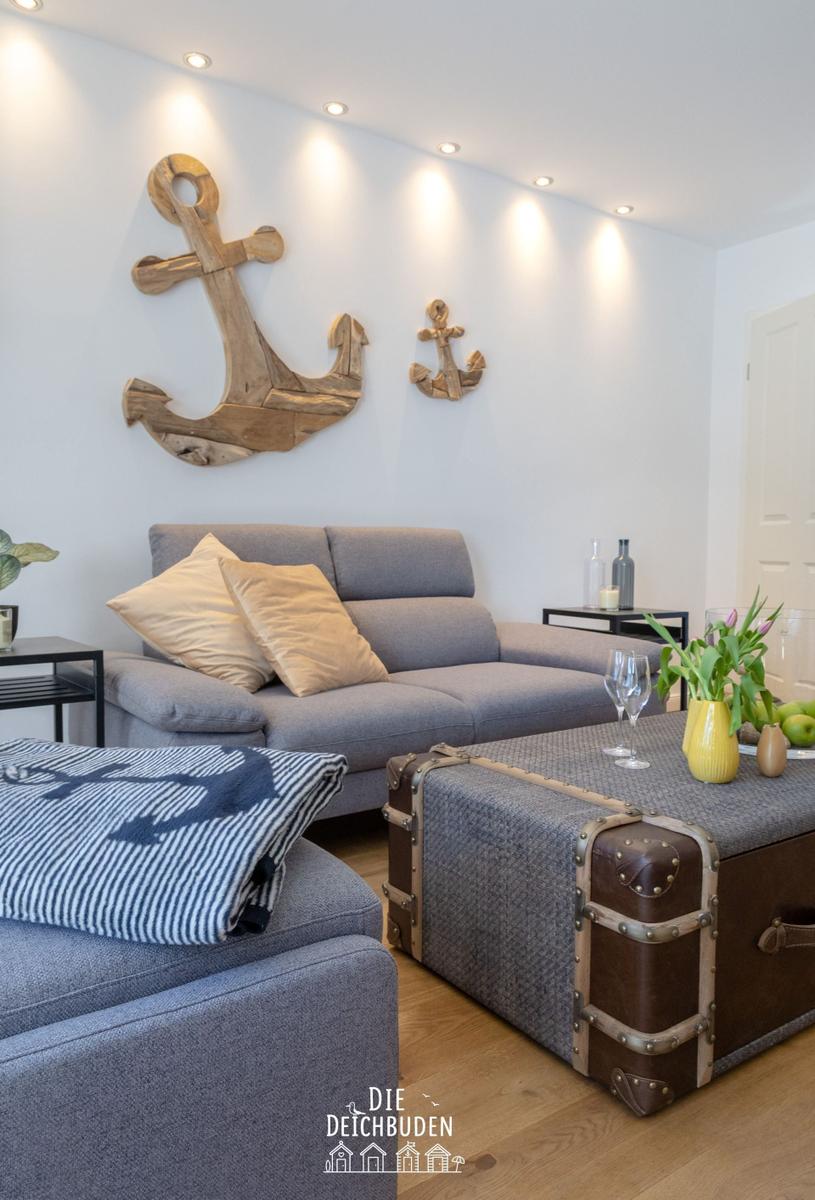Wohnzimmer mit Sofa, Koffer-Tisch und Wanddekoration aus Anker.