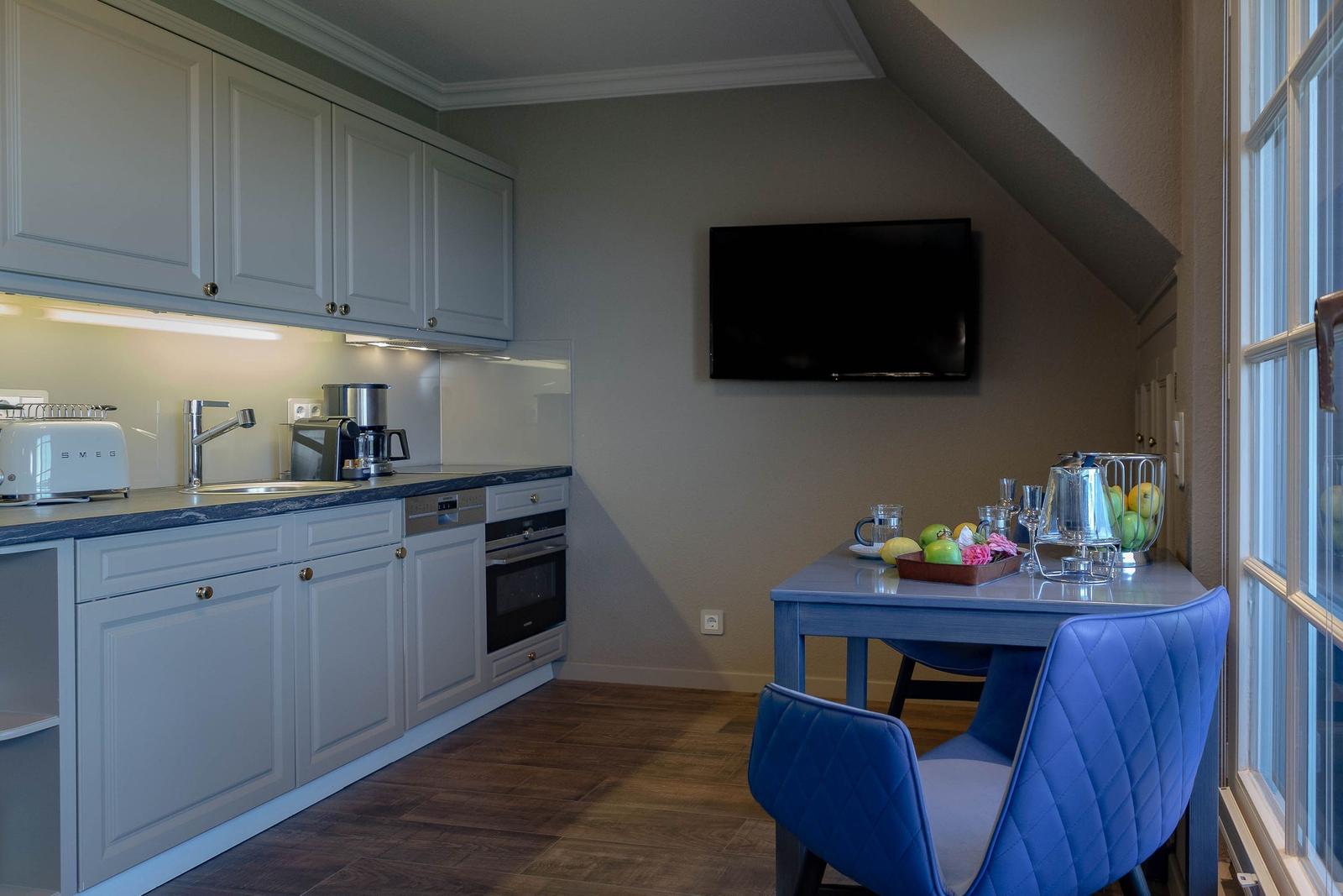 Küche mit Arbeitsplatz und TV an der Wand