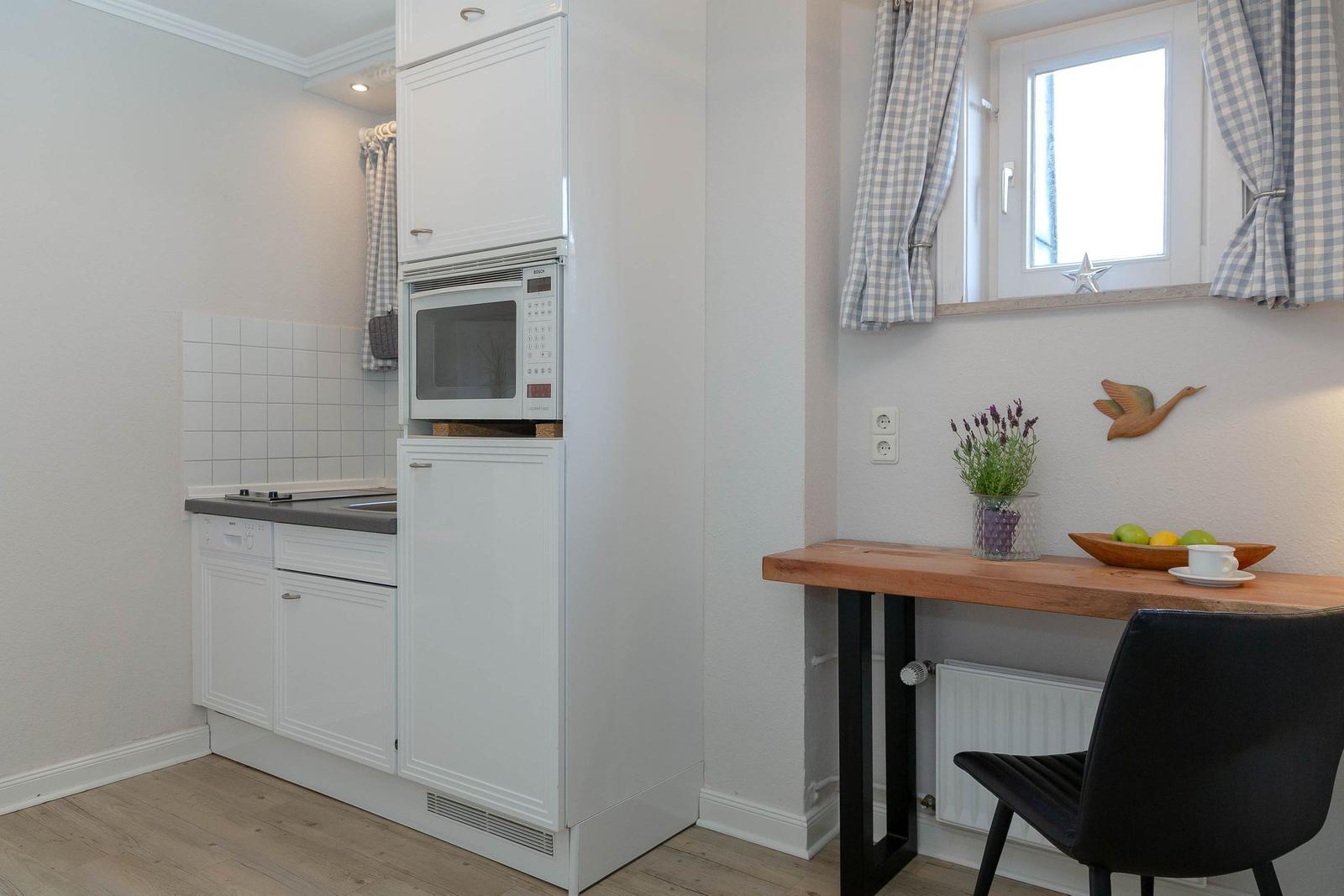 Küche mit Mikrowelle und Esstisch mit Stuhl