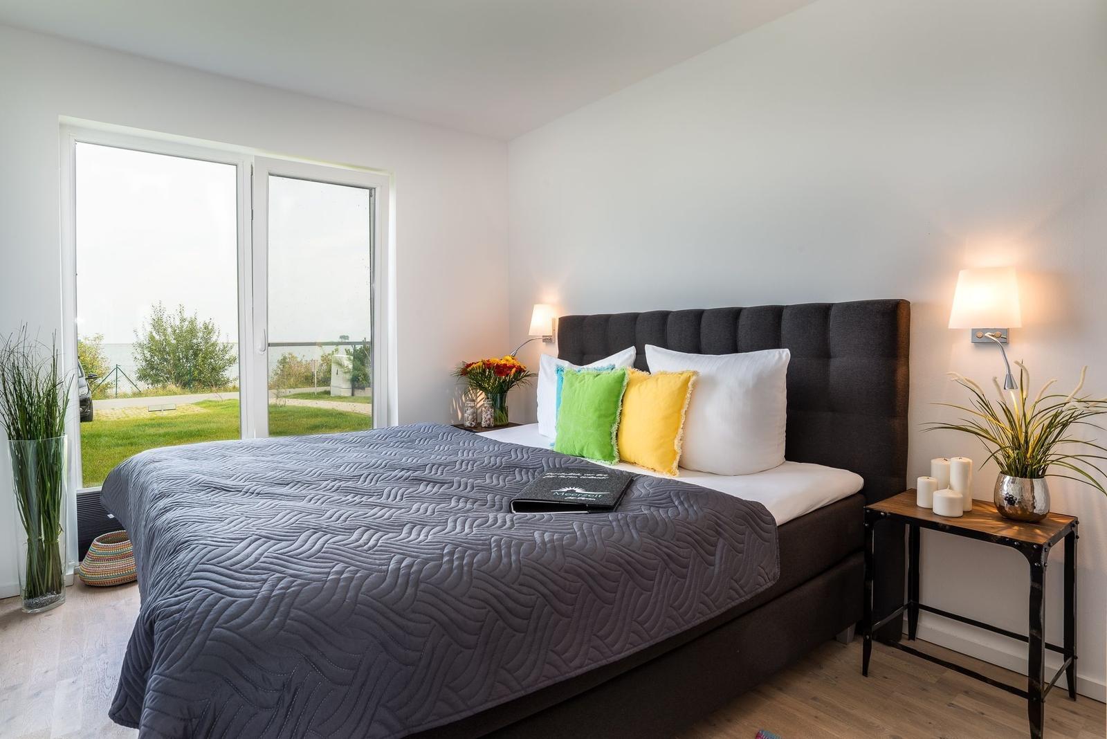 Schlafzimmer mit Bett, Fenster und Nachttisch