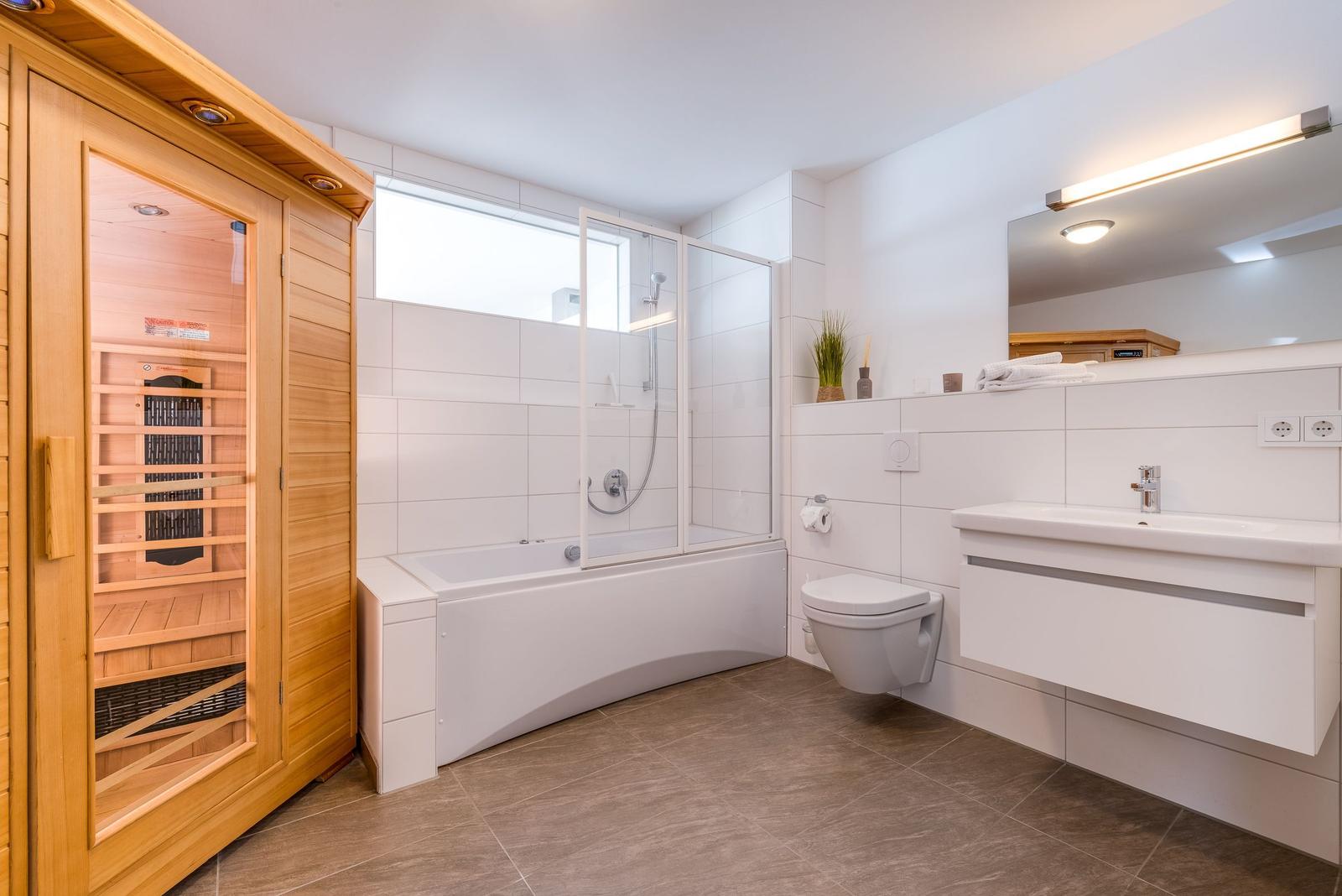 Bathroom with sauna, shower, bathtub, and sink