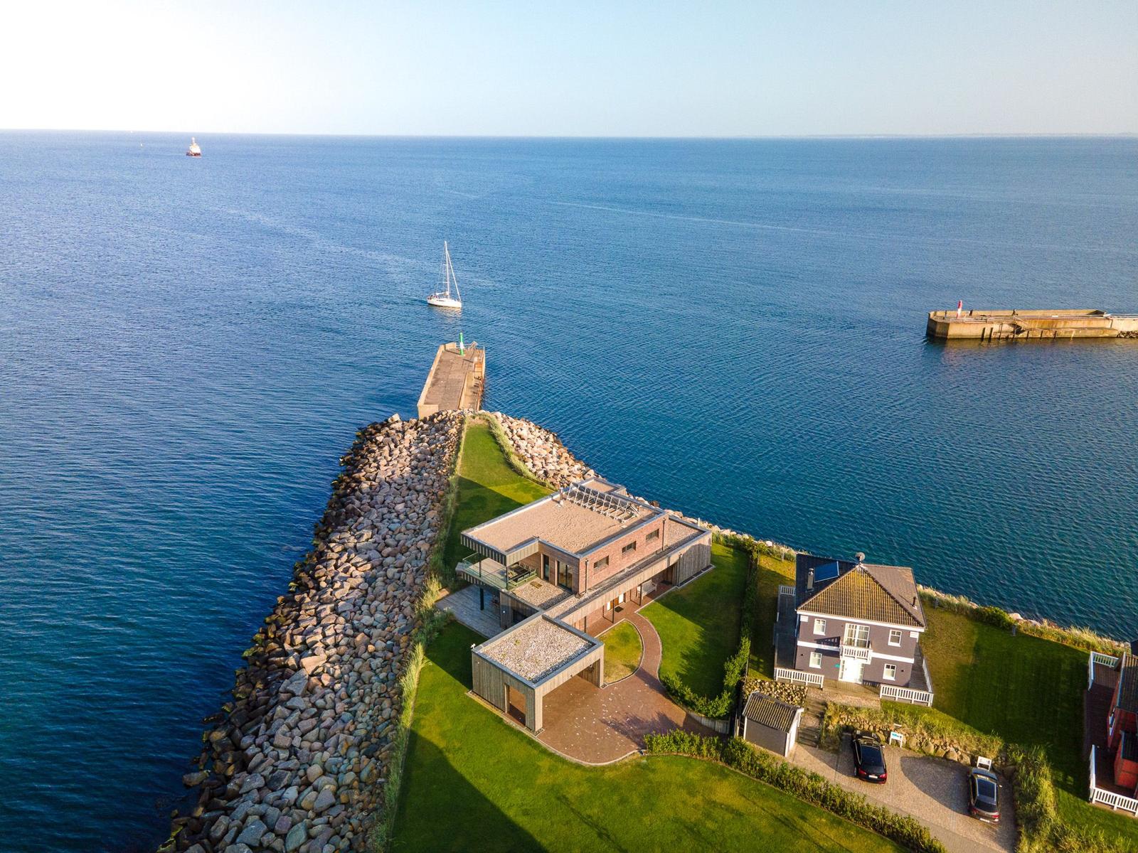 Modernes Haus mit Pool und Blick aufs Meer. Steinfassade und Gartenbereich.