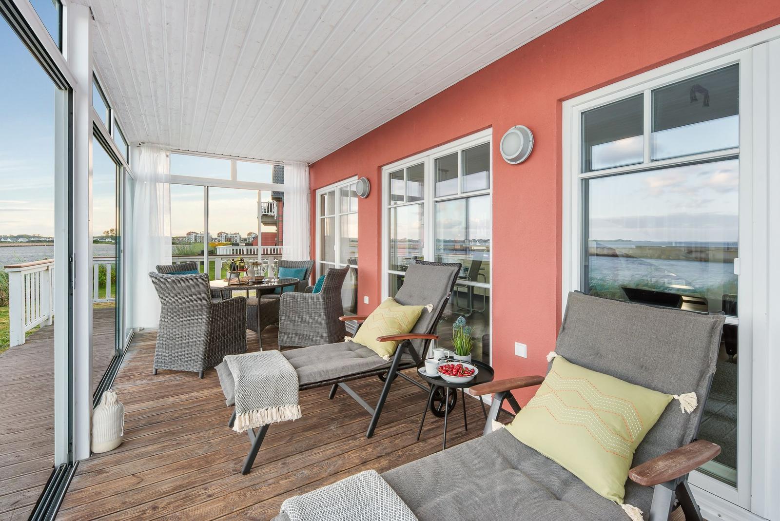 Terrasse mit Loungemöbeln und Blick auf Wasser