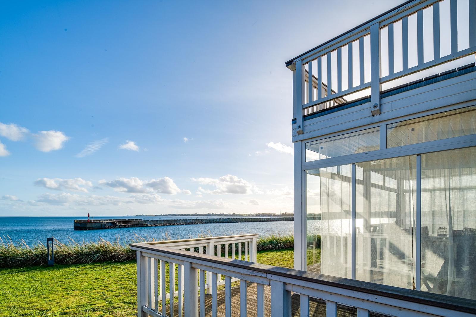 Haus mit Terrasse und Blick auf Meer und Hafen.