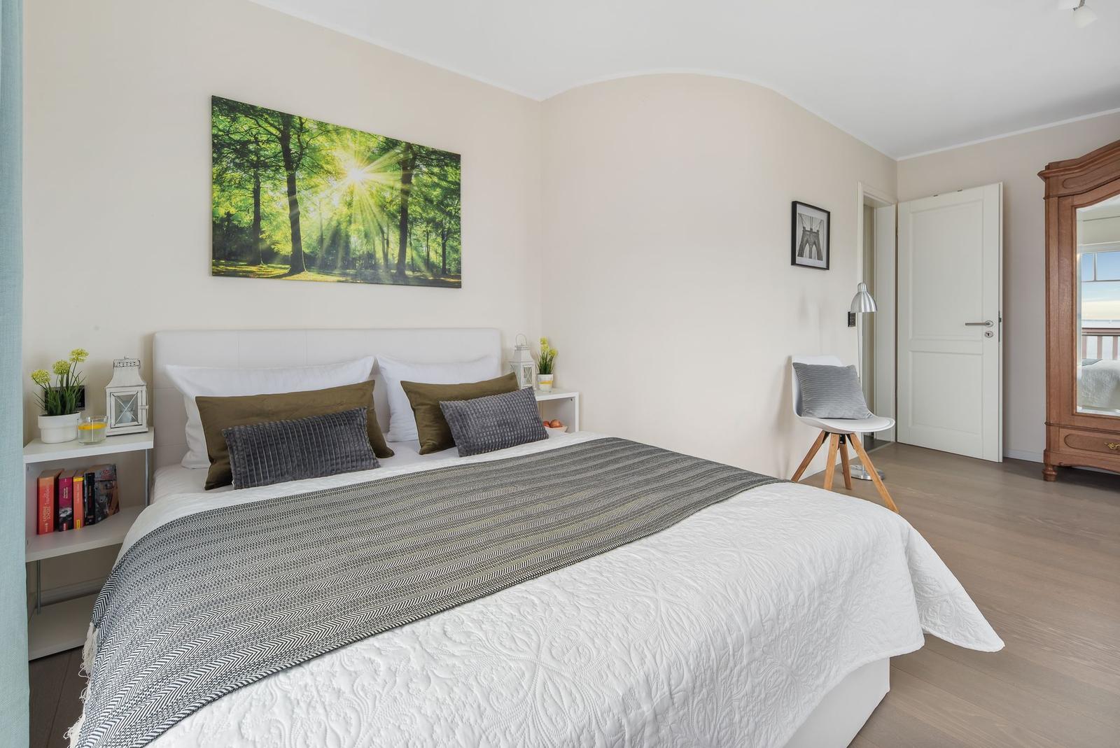 Schlafzimmer mit Bett, Wandbild und Holzboden