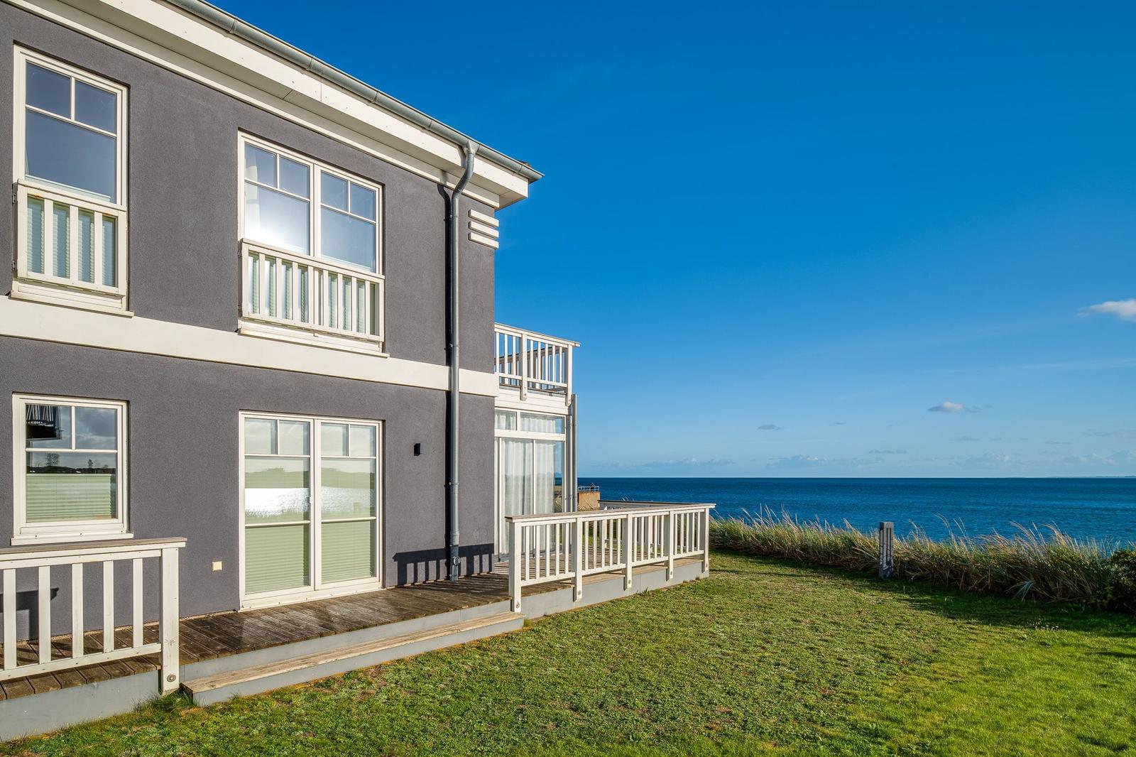 Ein zweistöckiges Haus mit Balkon und Blick auf das Meer.