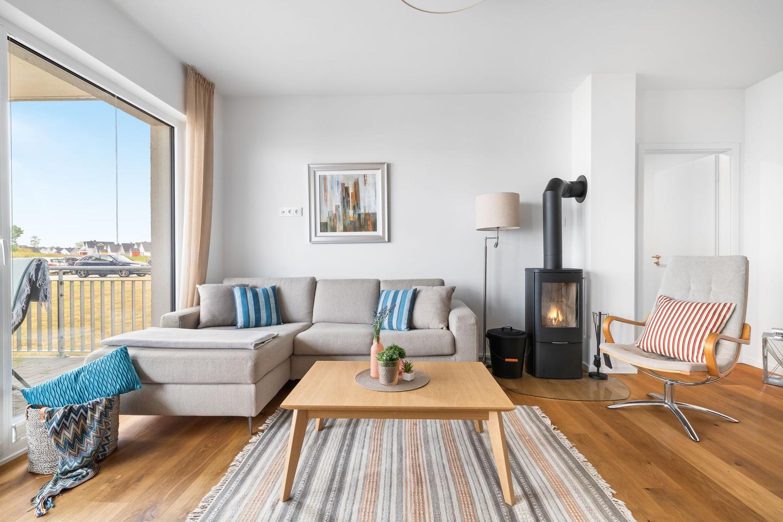 Wohnzimmer mit Sofa, Kamin und Terrassentür.