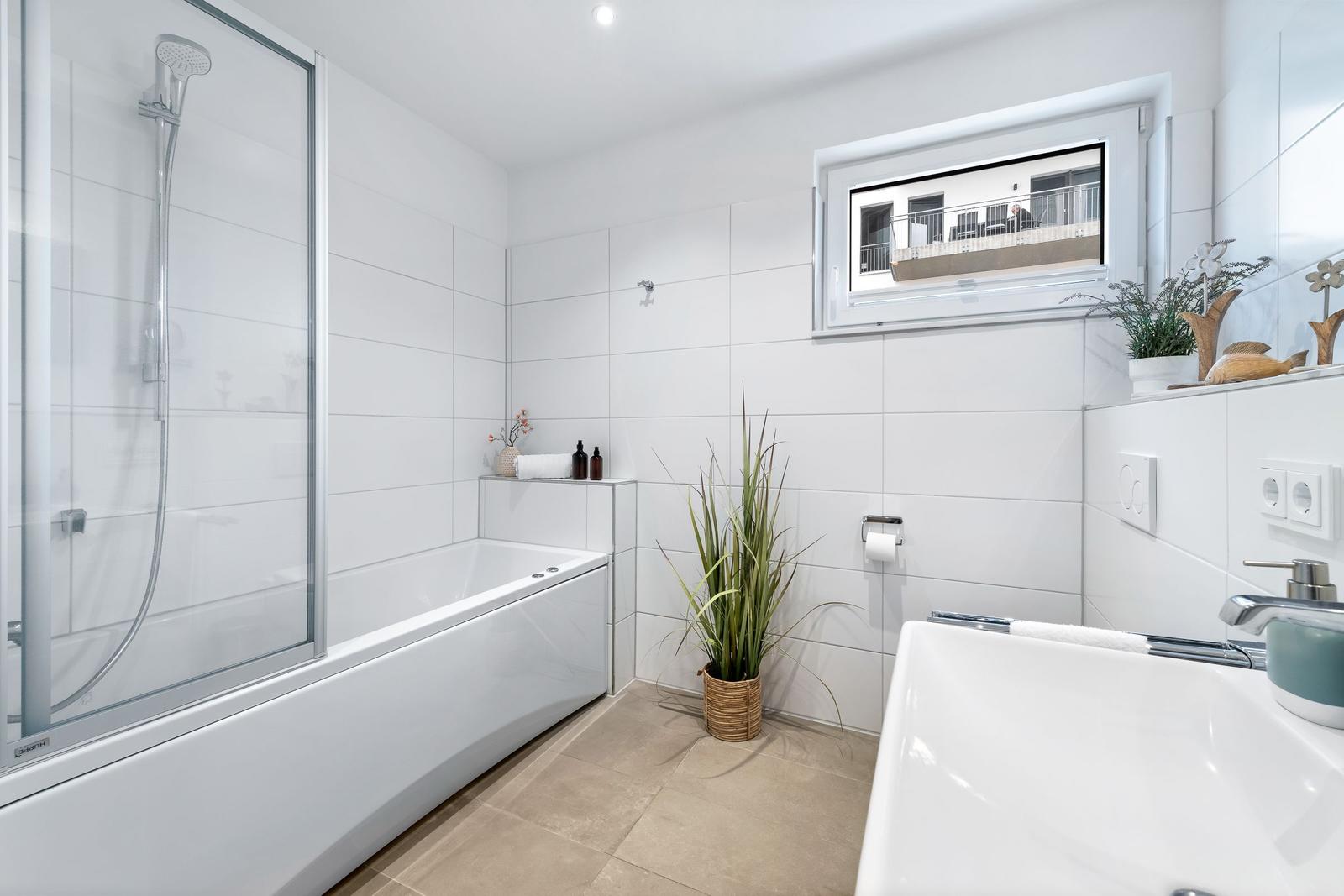 Bad mit Dusche, Badewanne, Waschbecken und Pflanze