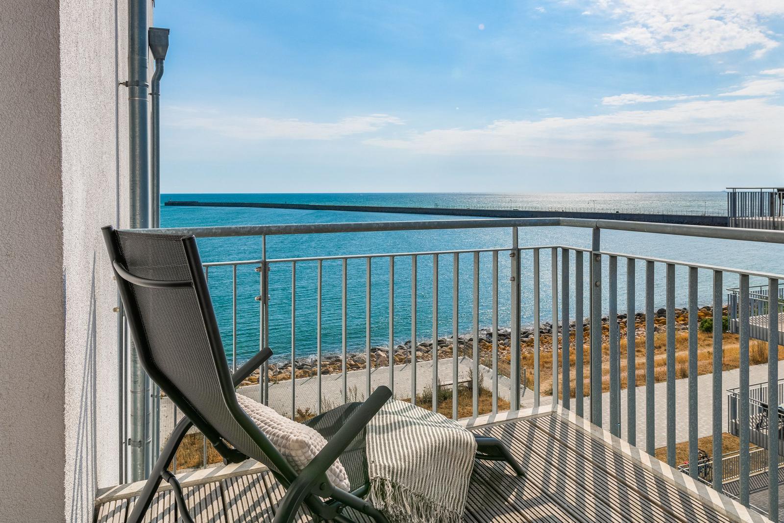 Terrasse mit Liegestuhl und Blick auf das Meer.