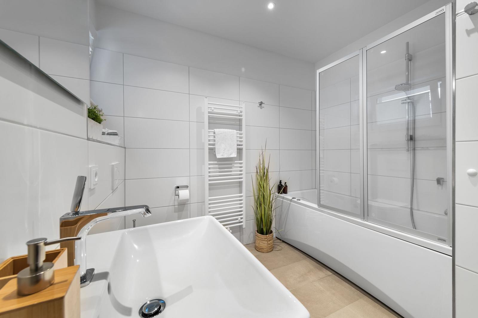 Badezimmer mit Badewanne, Dusche und Waschbecken.