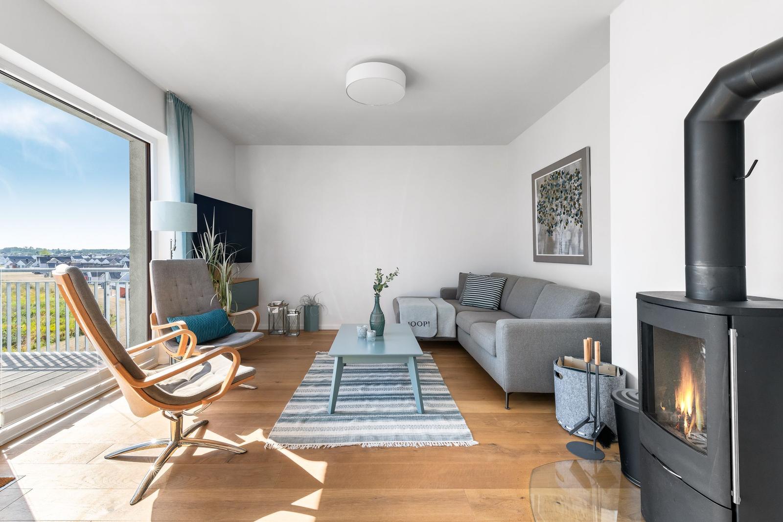 Living room with sofa, fireplace, and balcony view