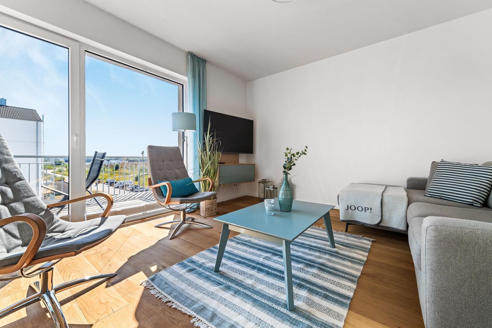Living room with sofa, coffee table, and balcony view