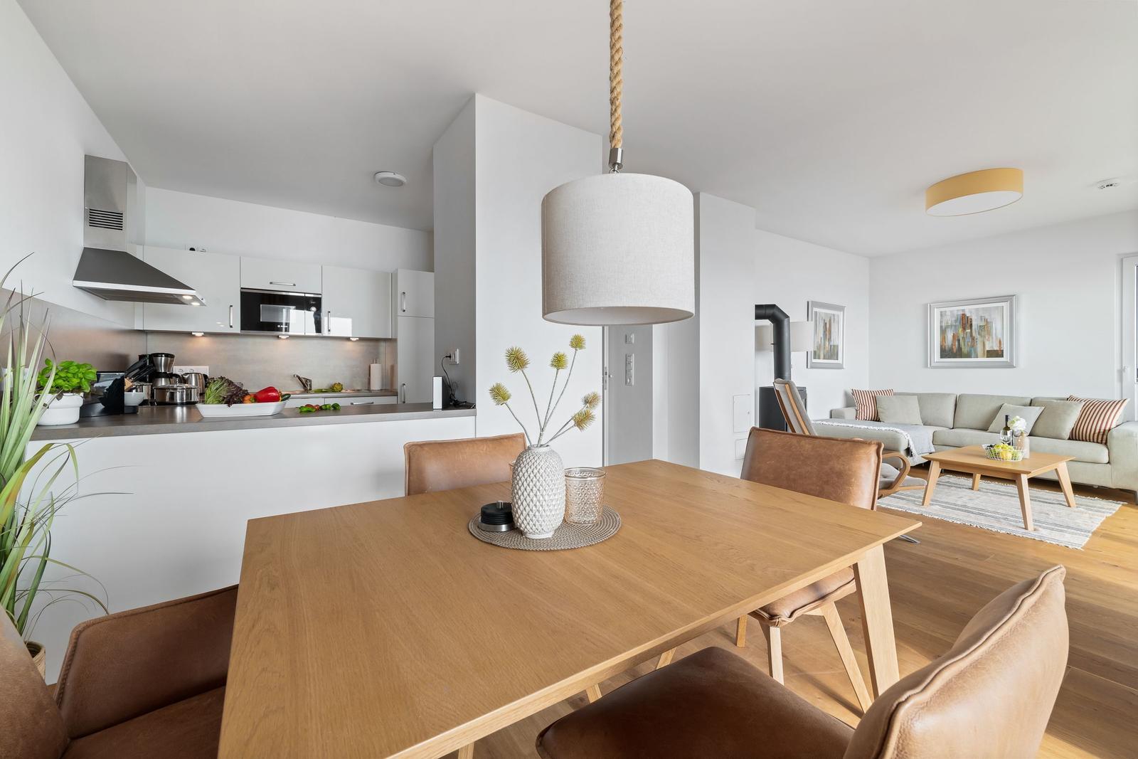 Moderne Küche mit Essbereich und Wohnzimmer im Hintergrund.
