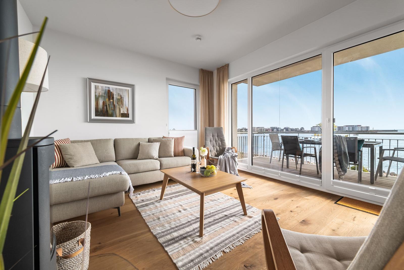 Wohnzimmer mit Sofa, Couchtisch und Balkon mit Meerblick.