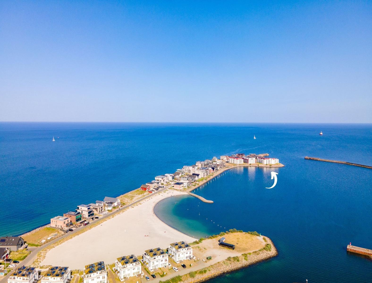 Strand und Hafen mit Häusern und Segelbooten im klaren Blauen Meer.