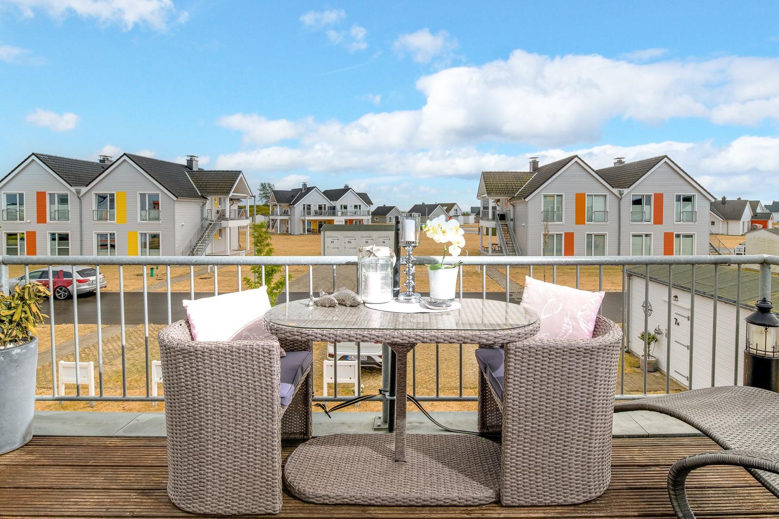 Terrasse mit Sitzgruppe und Blick auf moderne Häuser.