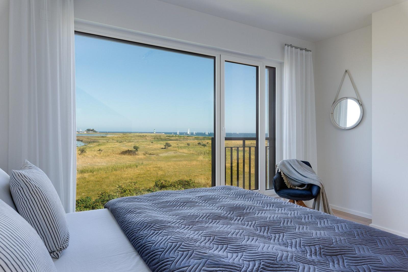 Schlafzimmer mit Blick auf Wiese und Meer