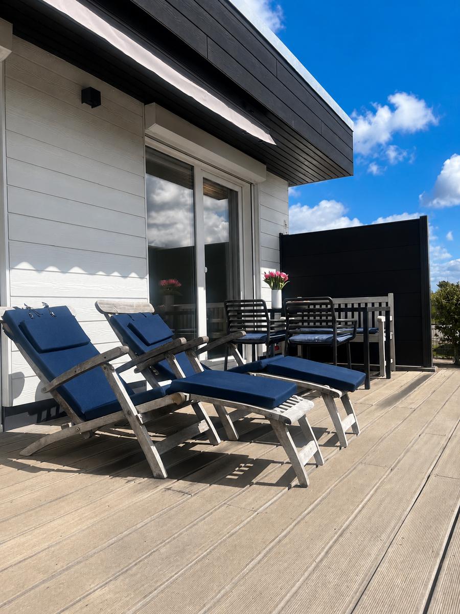 Sonnen-Terrasse mit Deckchairs und Marquise