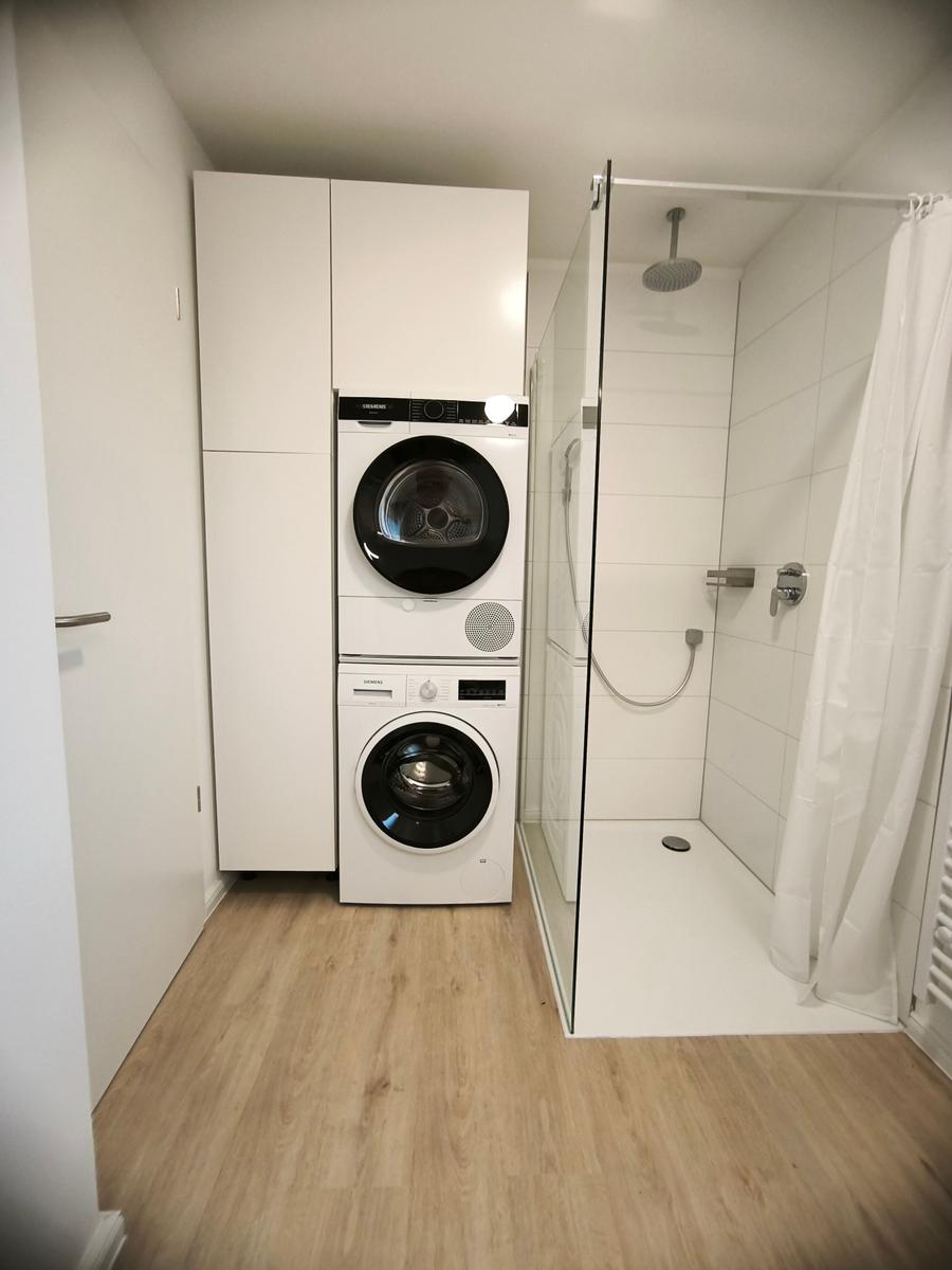 Badezimmer: Waschmaschine/Trockner und Walk-In-Dusche