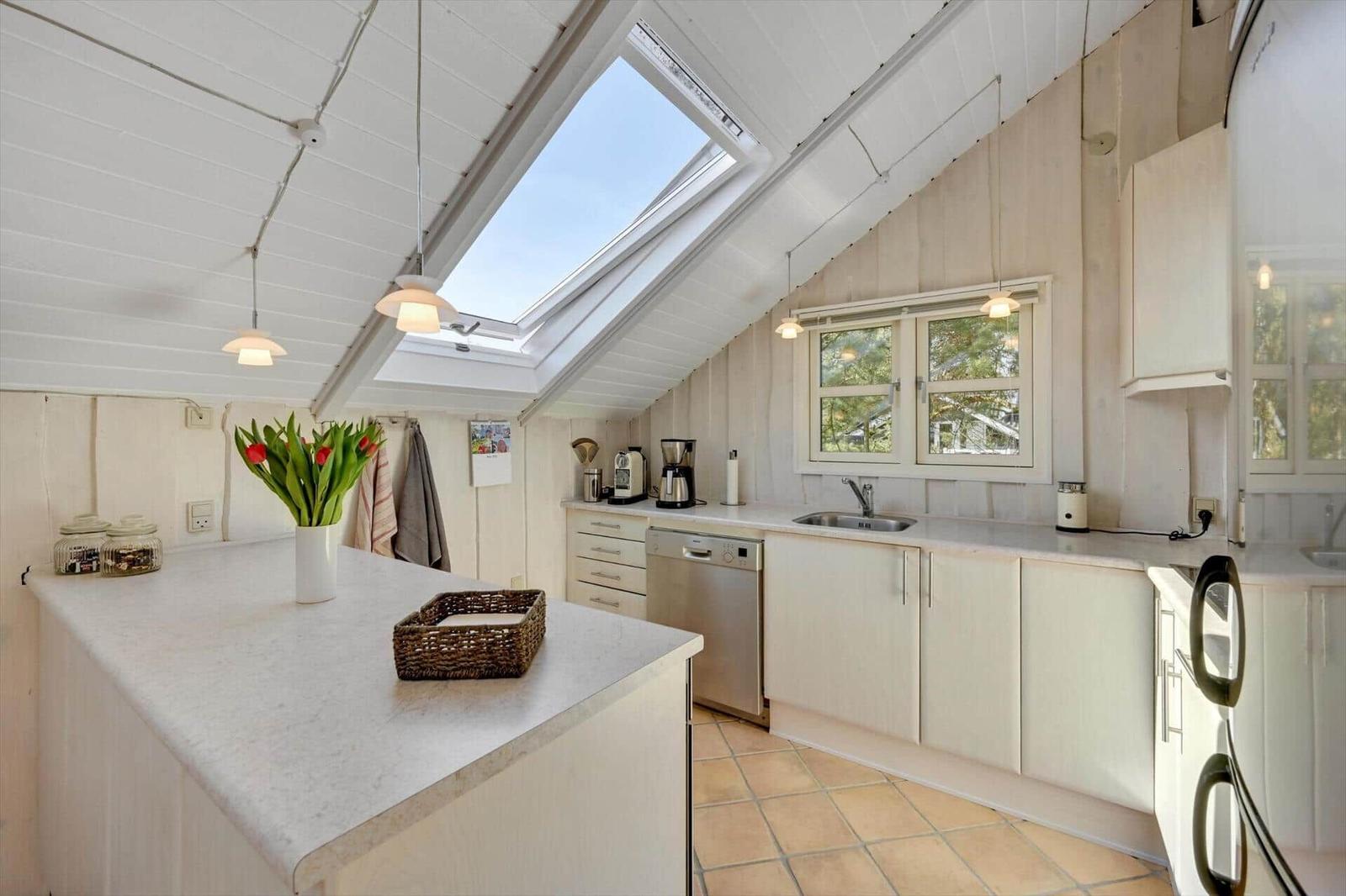 Kitchen with skylight, countertop, sink, and refrigerator.