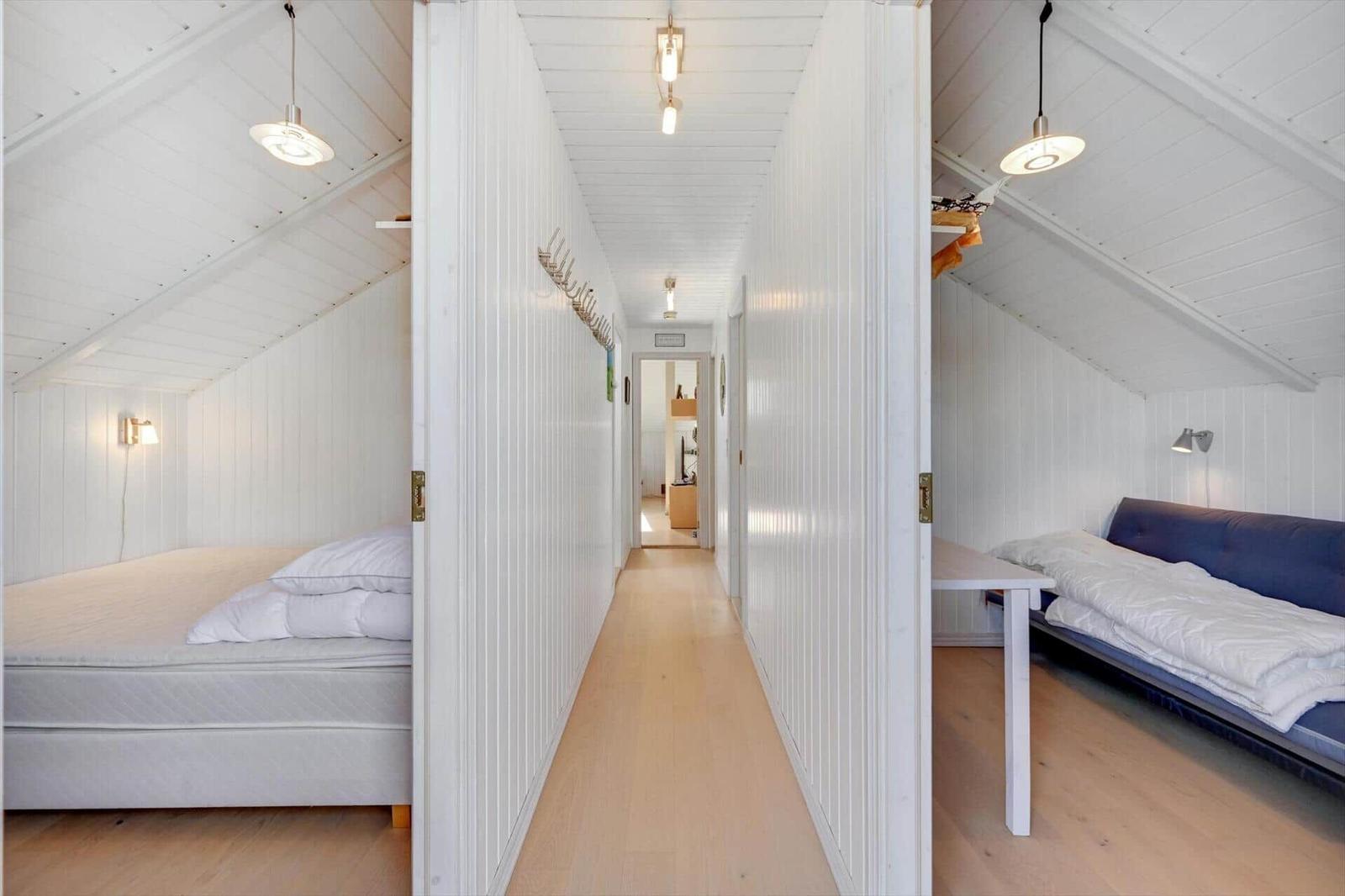 Two bedrooms with mattresses and table in hallway