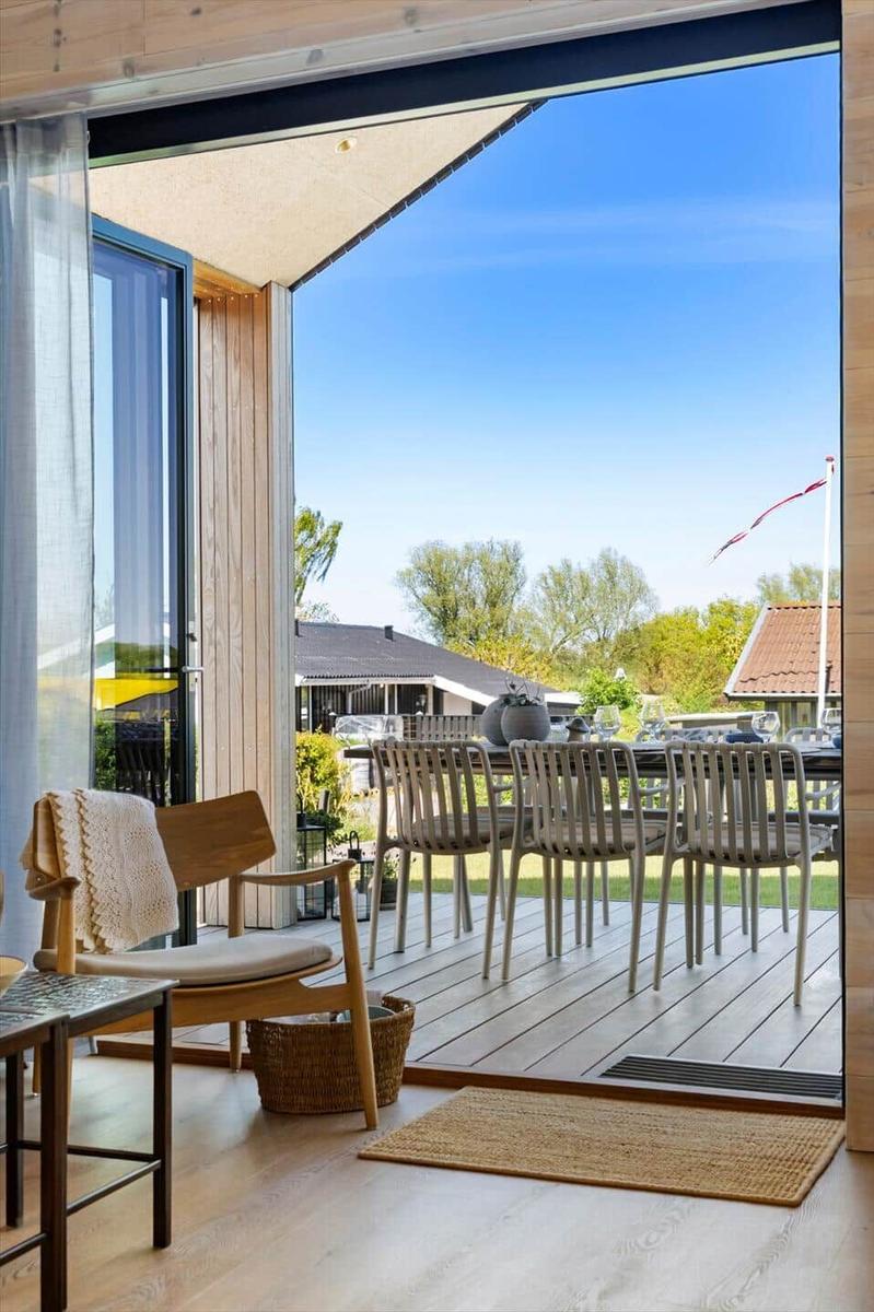 Deck with table and chairs, view of green landscape and sky