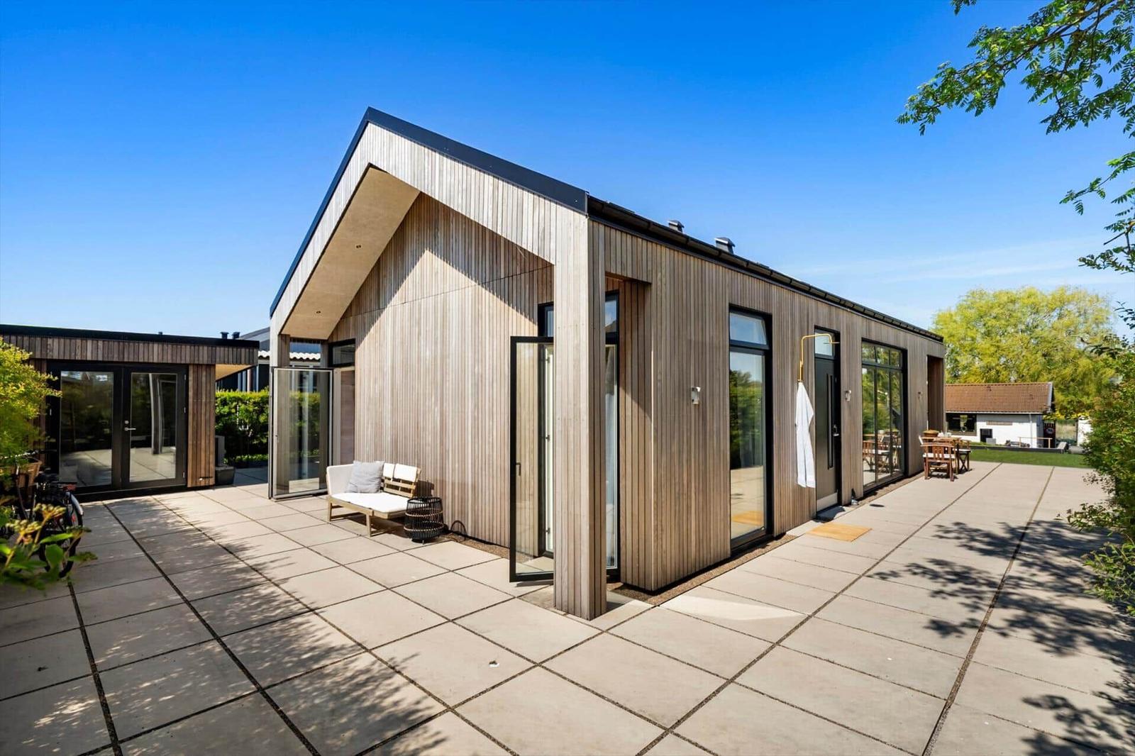 Modern wooden houses with large outdoor area and glass facades.