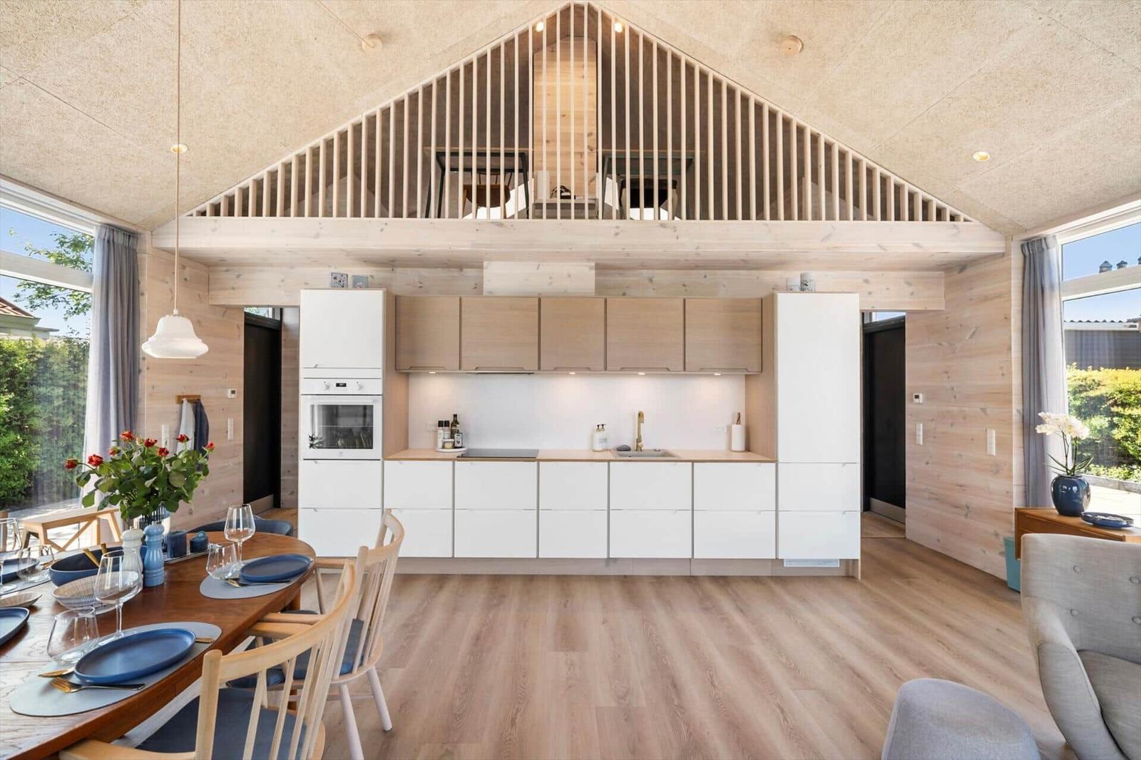 Kitchen with dining area and upper level, wooden ceiling and walls.
